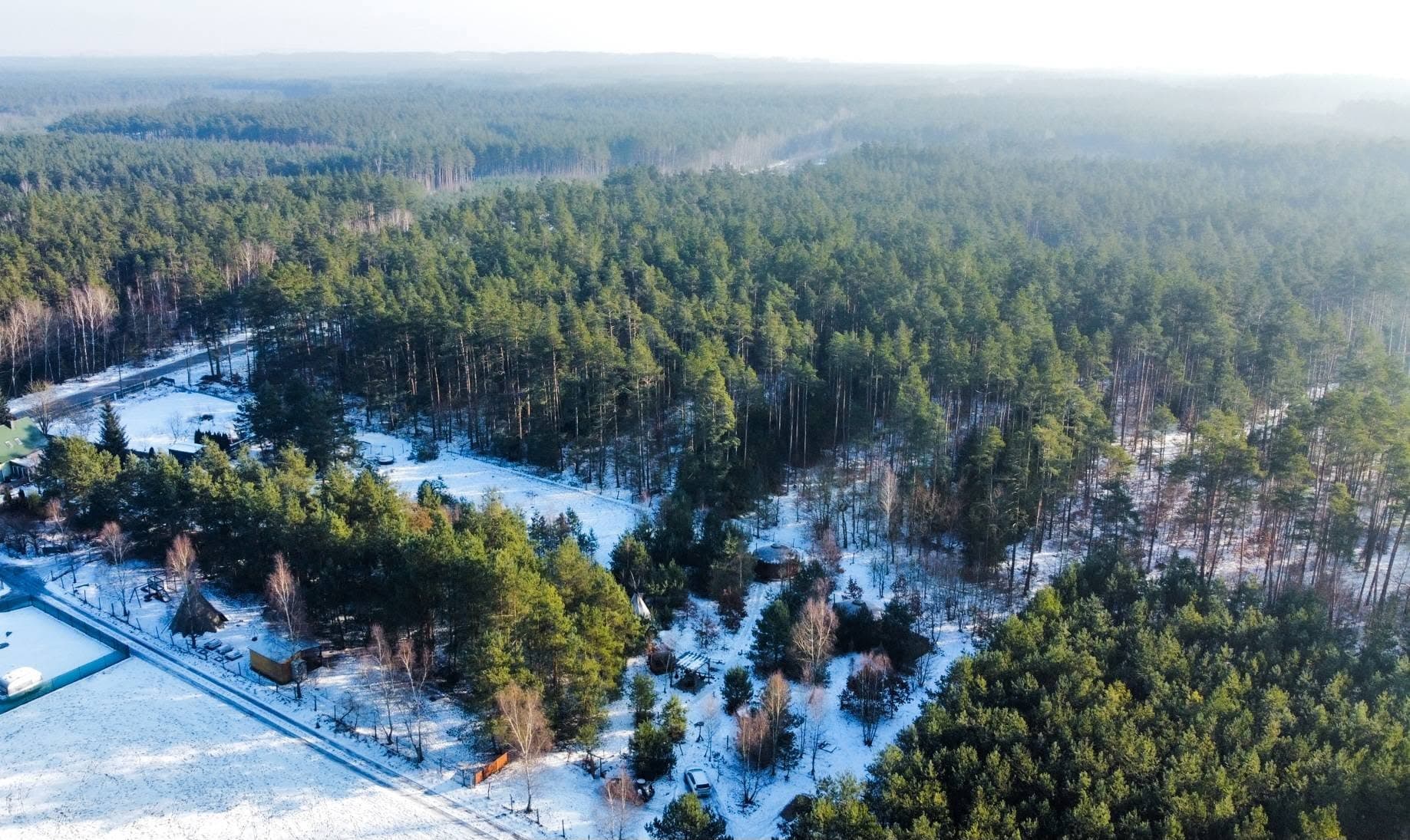 Panorama z drona na siedlisko jurt otoczone lasem i polami zimą