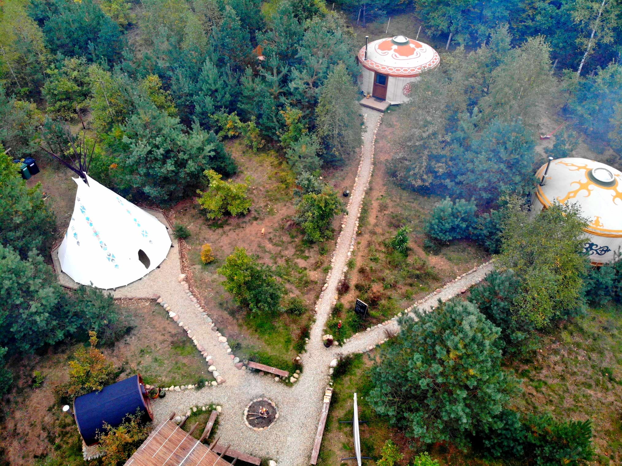 Tipi, jurty i sauna z drona, żwirowe ścieżki łączące całe siedlisko