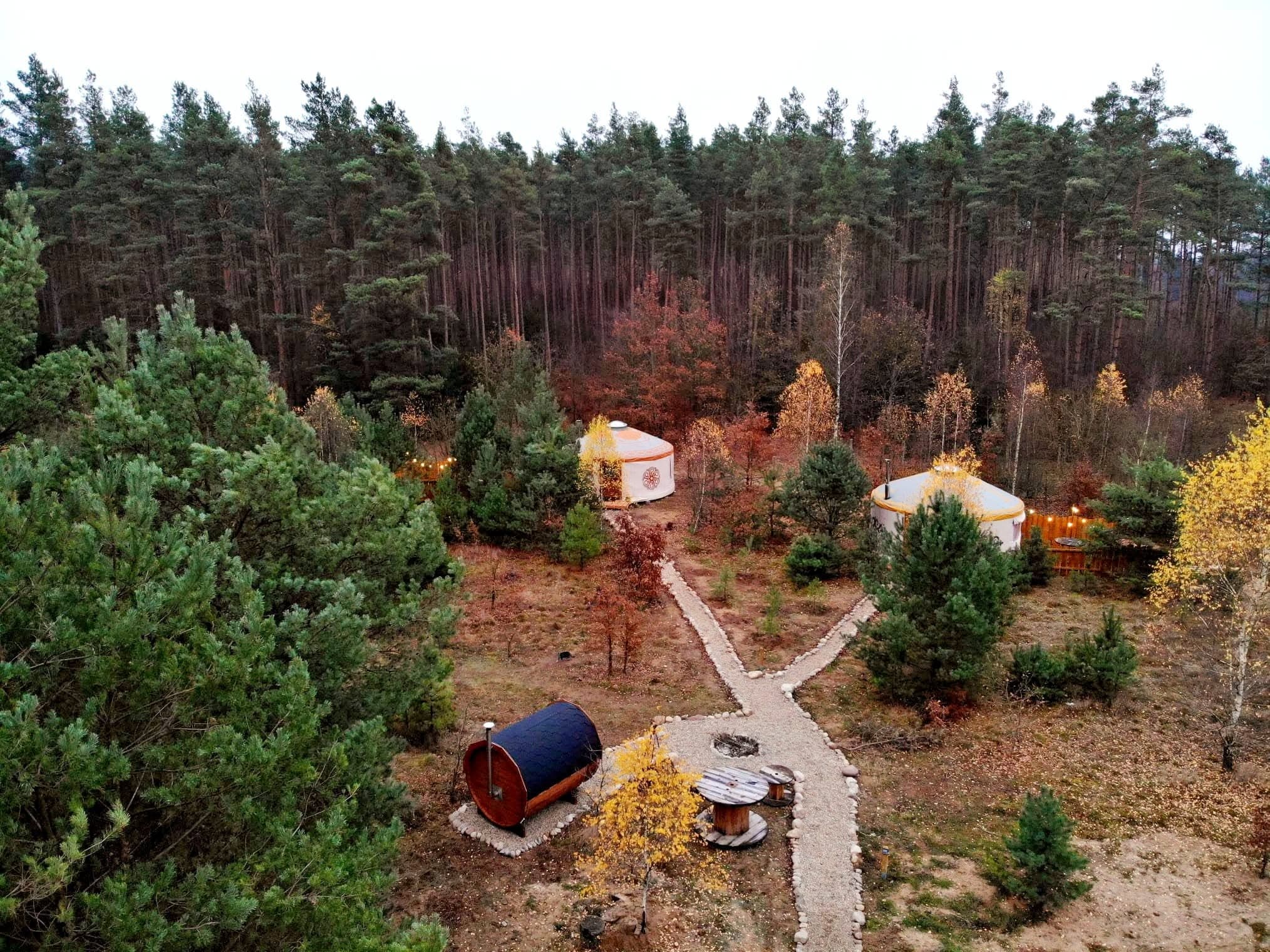 Jurty i tipi z lotu ptaka jesienią, ścieżki wijące się między drzewami